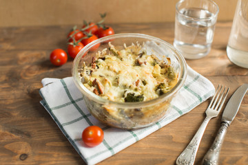 Tomato gratin with cheese and zucchini in baking dish