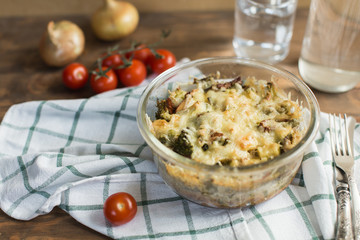 Tomato gratin with cheese and zucchini in baking dish