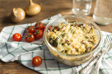 Tomato gratin with cheese and zucchini in baking dish