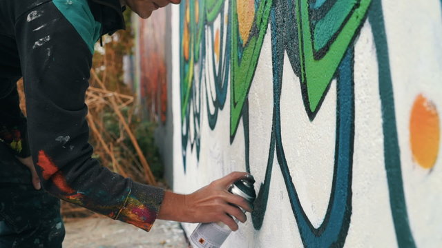 Graffiti artist drawing on the wall, close up, slow motion