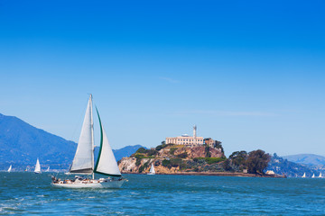 Yacht sail in front of Alcatraz prison island - obrazy, fototapety, plakaty
