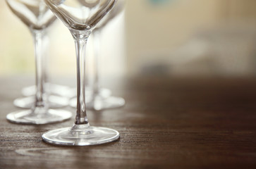 Empty wine glasses on wooden table against blurred background