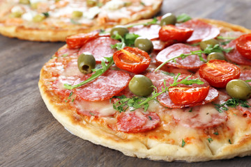 Delicious tasty pizzas with ingredients on table, closeup
