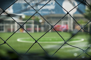 Goal nets / Close up of goal nets with wind and rain, background in blur.