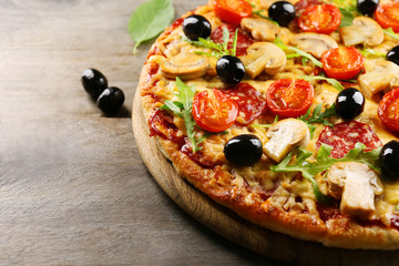 Delicious tasty pizza with ingredients on wooden table