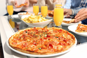 Friends hands holding hot pizza, close up