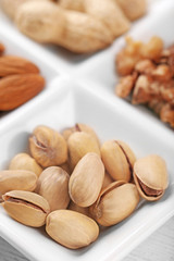 Walnut kernels, almonds, pistachios, peanuts in the ceramic rectangle plate, close-up