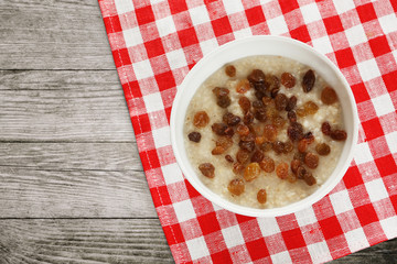 White bowl of oatmeal with raisins