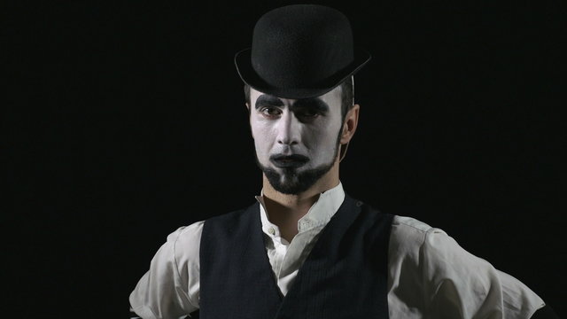 Young hilarious mime having a mask on the back of his head
