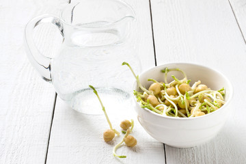 Sprouted chickpeas and a jug of spring water for cooking healthy