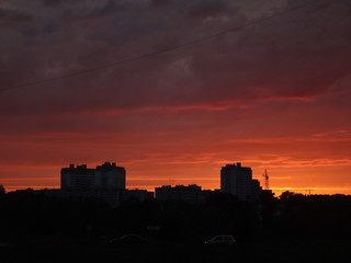 Красный закат над городом летним вечером