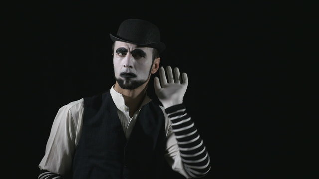 Young funny mime listening to something