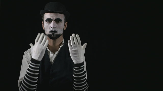 Young funny mime quarreling with somebody
