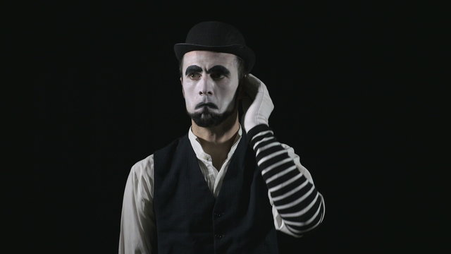 Young funny mime listening to music and dancing