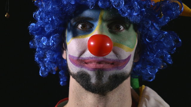 Close-up of young hilarious clown making funny faces