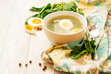 
healthy lunch , green soup with sorrel or spinach , boiled egg and spices on wooden background