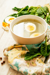 
healthy lunch , green soup with sorrel or spinach , boiled egg and spices on wooden background