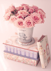 Roses in a vase over a girly box and vintage books