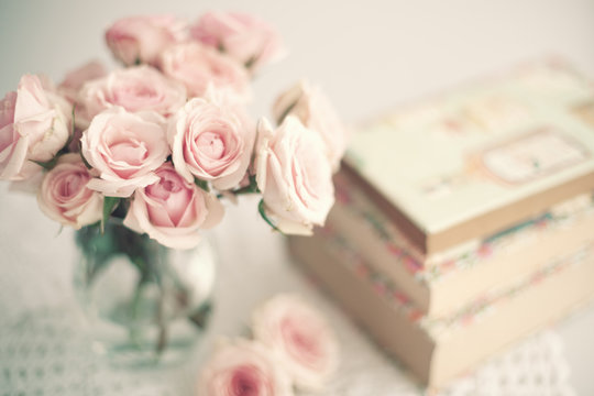 Roses in a crystal vase and books with vintage dust jackets