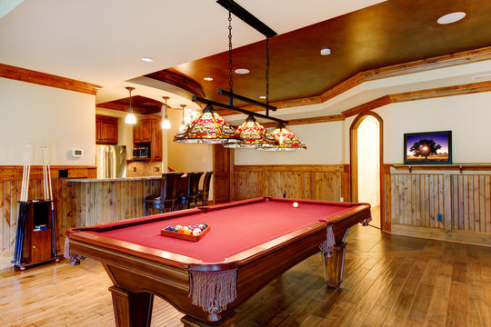 Large Hardwood Floor Room With Pool Table And Bar.