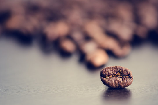 Coffee beans on a black background. Raw coffee beans. Grained product. Hot drink. Close up. Harvesting. Natural background. Energy