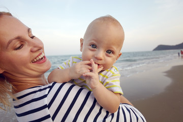 Lifestyle photo normal family with baby boys on the ocean coast