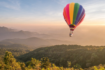 Fototapeta premium Hot air balloon above high mountain at sunset