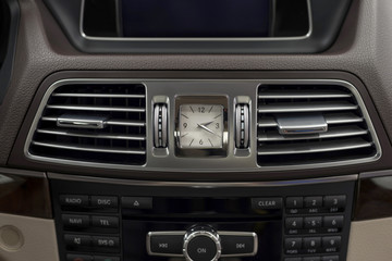 Modern car dashboard with clock and ventilation. Interior detail.