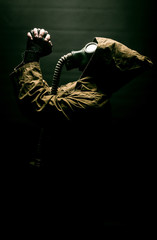 man in the gas mask in the hood praying to the god, survival human after apocalypse.