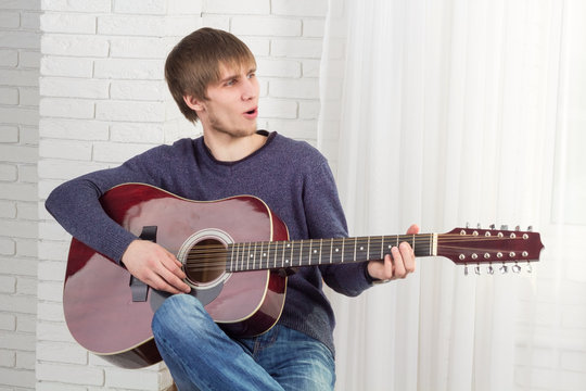 musician sings with a guitar