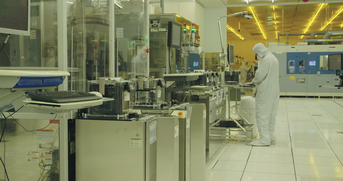 Workers in clean suits in a semiconductors manufacturing facility