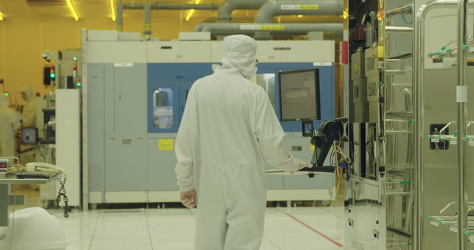 Workers in clean suits in a semiconductors manufacturing facility
