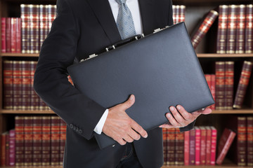 Businessman Holding Briefcase In Office