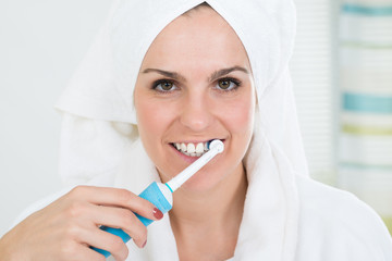 Woman Brushing Teeth With Electric Toothbrush