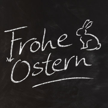 Handwritten Frohe Ostern on black chalkboard
