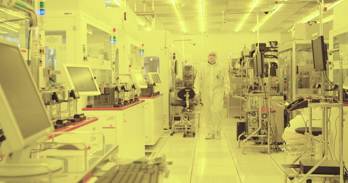 Workers in clean suits in a semiconductors manufacturing facility