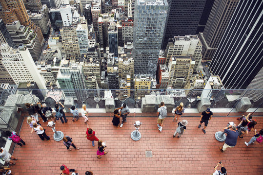 Tourist people taking pictures from rooftop on Manhattan skyscraper