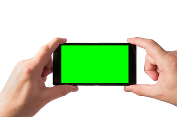 Man holds in two hands smartphone in landscape mode with green screen isolated on white. Chroma key screen for placement of your own content.
