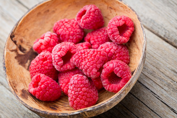 Frozen raspberries on wooden background.