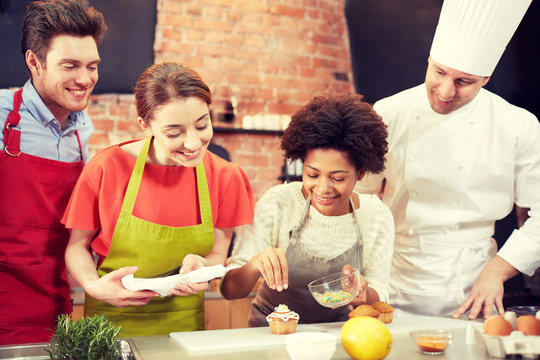 happy friends and chef cook baking in kitchen