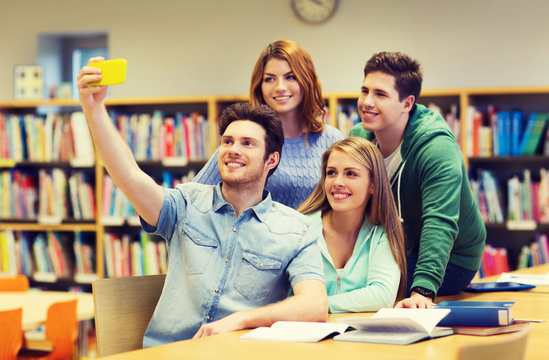 students with smartphone taking selfie at library