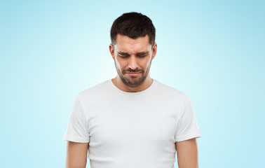 Fototapeta premium unhappy young man over blue background