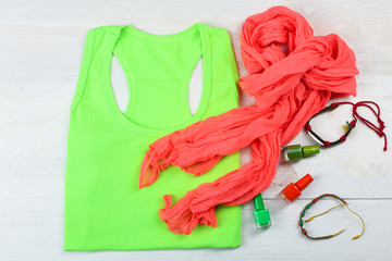 red scarf with t-shirt and nail Polish on a wooden table