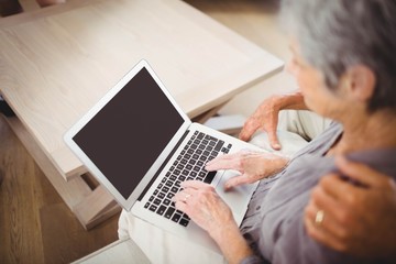 Senior woman using laptop in living room