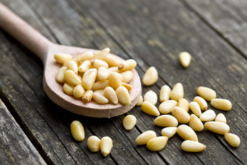 pine nuts on wooden spoon