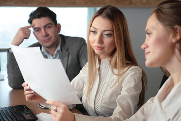 Fototapeta premium three people studying the paper in the office at the table