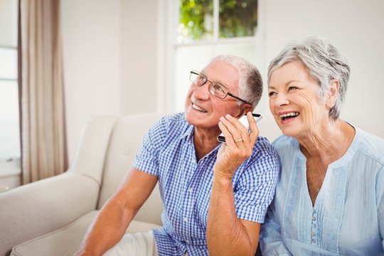 Senior Couple Talking On Mobile Phone