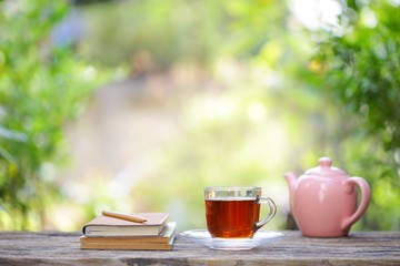 pink vintage  teapot  with a cup of glass tea and notebooks with flower 