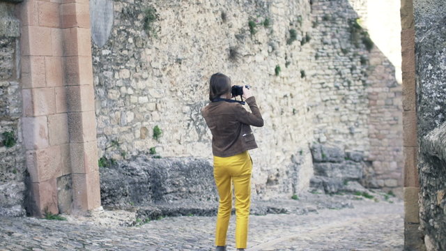 Woman taking photo of ancient wall in Andalusia in Spain
