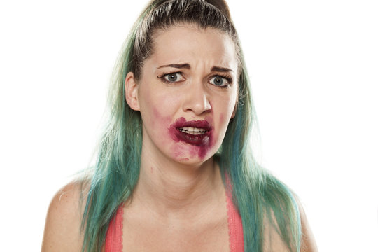 frightened beautiful young woman with smeared lipstick